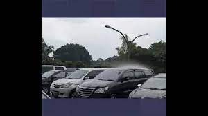 أمطار تهطل على سيارة واحدة فقط بين عشرات السيارات في موقف بإندونيسيا