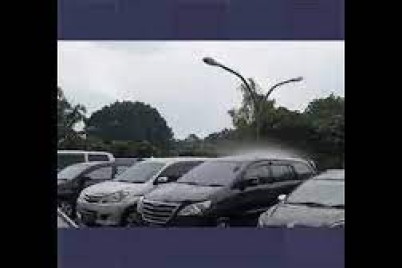 أمطار تهطل على سيارة واحدة فقط بين عشرات السيارات في موقف بإندونيسيا